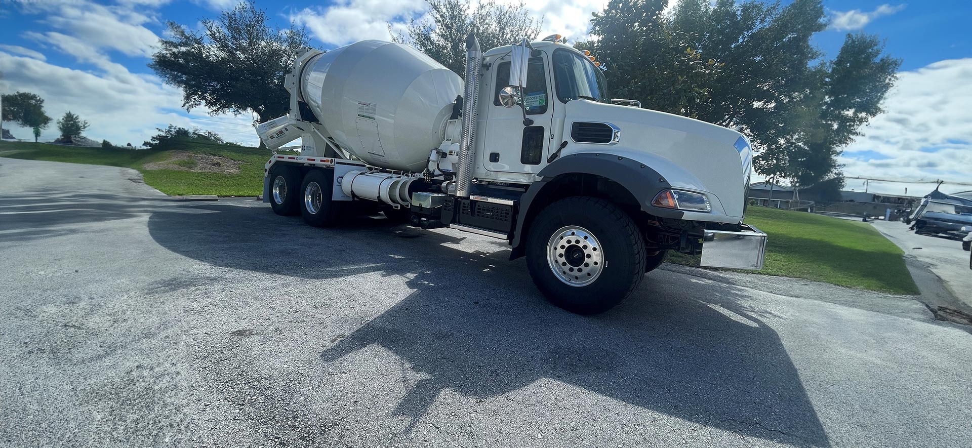 A cement truck is parked on the side of the road.